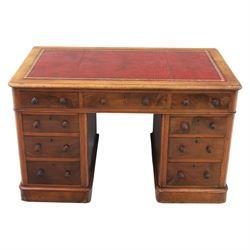 Victorian mahogany writing desk, featuring inset tooled red leather top, raised on two pedestals, nine drawers with figured veneer fronts