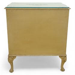 French design cream painted three drawer commode, shaped front with floral garland appliqués, fluted uprights and acanthus carved cabriole legs terminating in scroll feet