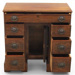 Early 20th century Georgian design figured walnut kneehole desk, rectangular moulded top over one long frieze drawer, kneehole recess with cupboard and drawer above, flanked by six short drawers with oval pressed brass handle plates, moulded plinth base on bracket feet