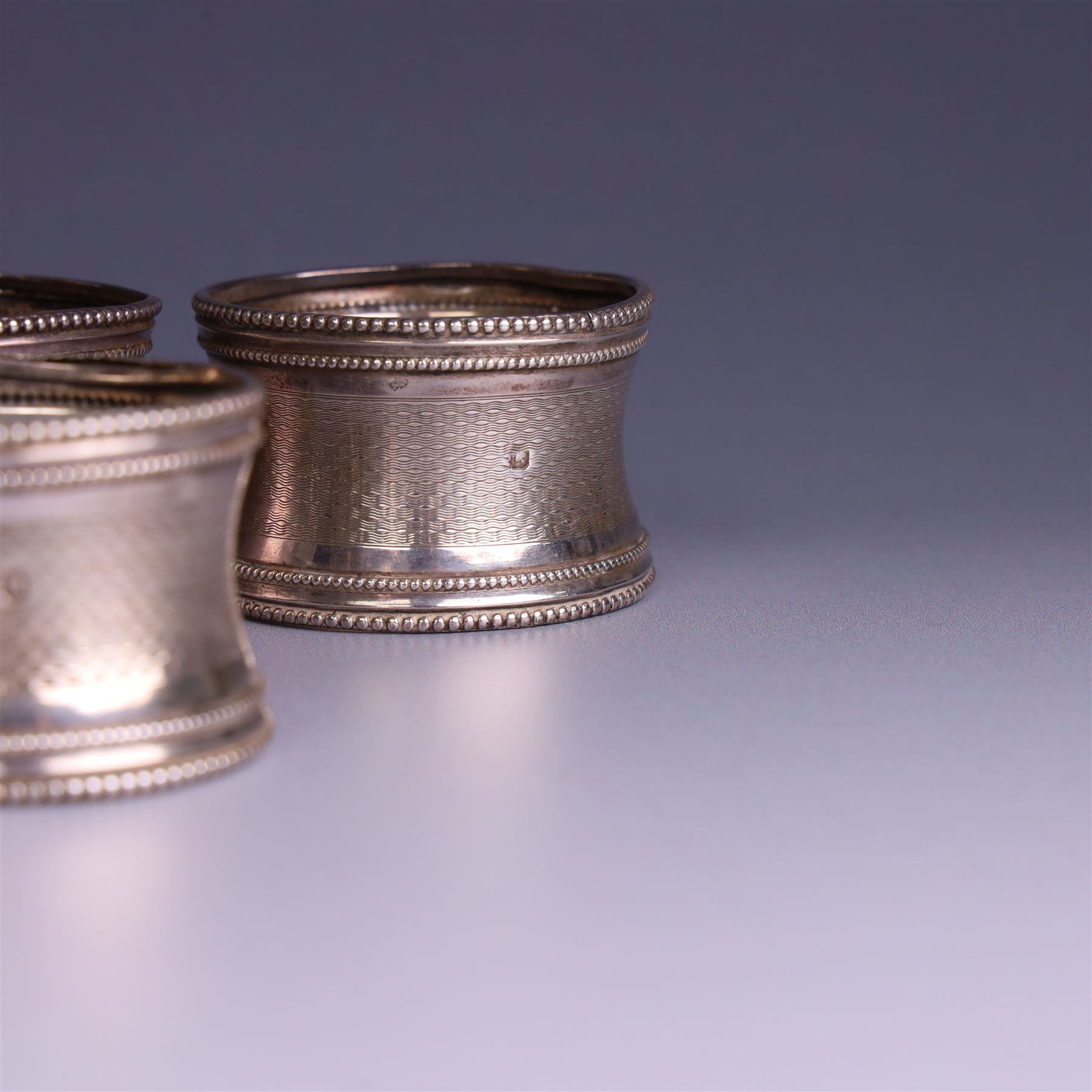Six early 20th century French silver napkin rings, each with engraved initials, stamped with Minerva mark for 950 standard silver and maker's mark for Claude Doutre Roussel 
