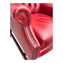 Kingsgate - contemporary 'Suffolk' wingback armchair and matching stool, upholstered in red leather with deep button tufting and brass stud trim, raised on square section supports 