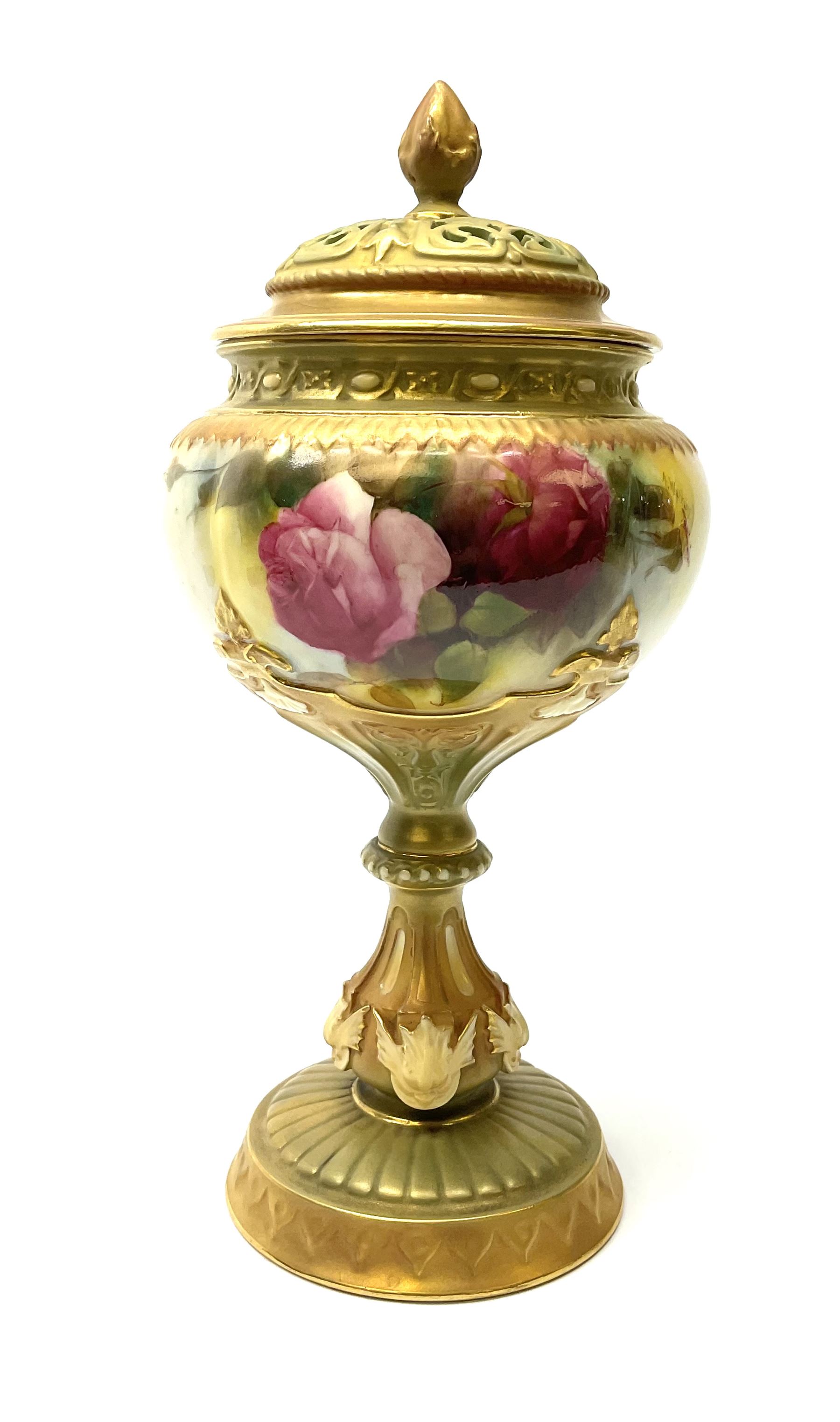 A Royal Worcester potpourri vase and cover, shape 1813, the bulbous body hand painted with pink roses and signed A Watkins, supporting a gilded and burnished pierced cover, upon a moulded stem with zoomorphic mask detail and circular foot, with puce printed mark beneath, H24cm