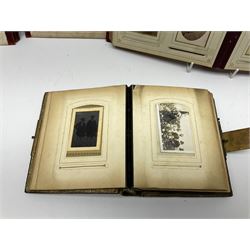 Three Victorian musical albums including one leather bound smaller example all with brass fixtures and interior gilt decoration bordering the apertures of portraits of various sizes and shapes, with boxed cylindrical movements