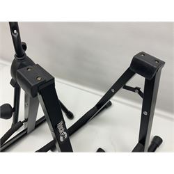 Four folding tubular guitar stands, two by RockJam; and folding tubular saxophone stand (5)