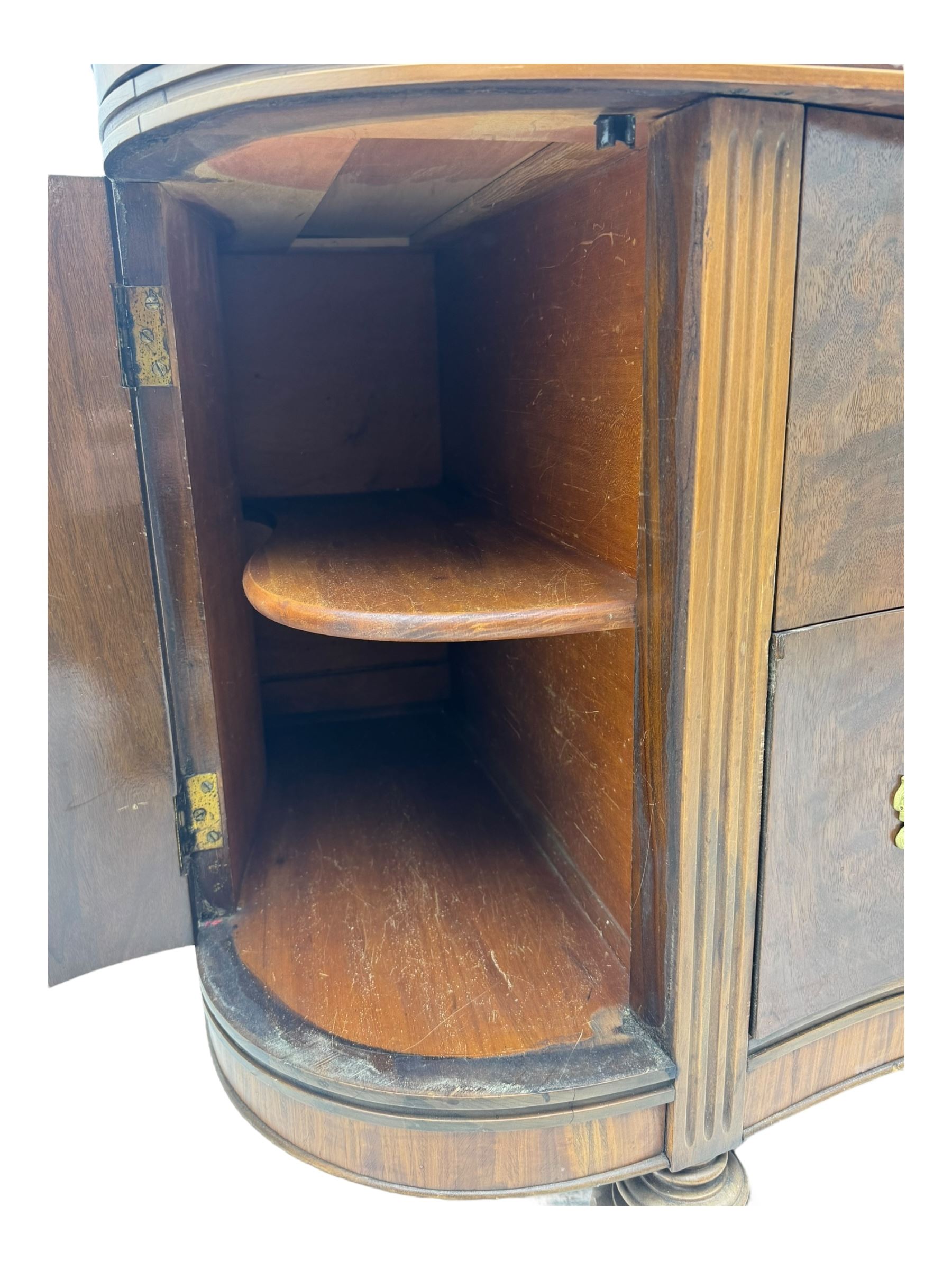 Late 20th century Italian walnut sideboard, serpentine front and bow-shaped top with highly figured veneer, single checkered-pattern frieze drawer over two drawers with central foliage cartouche, flanked by hinged frieze drawers over cupboards, on turned and carved supports