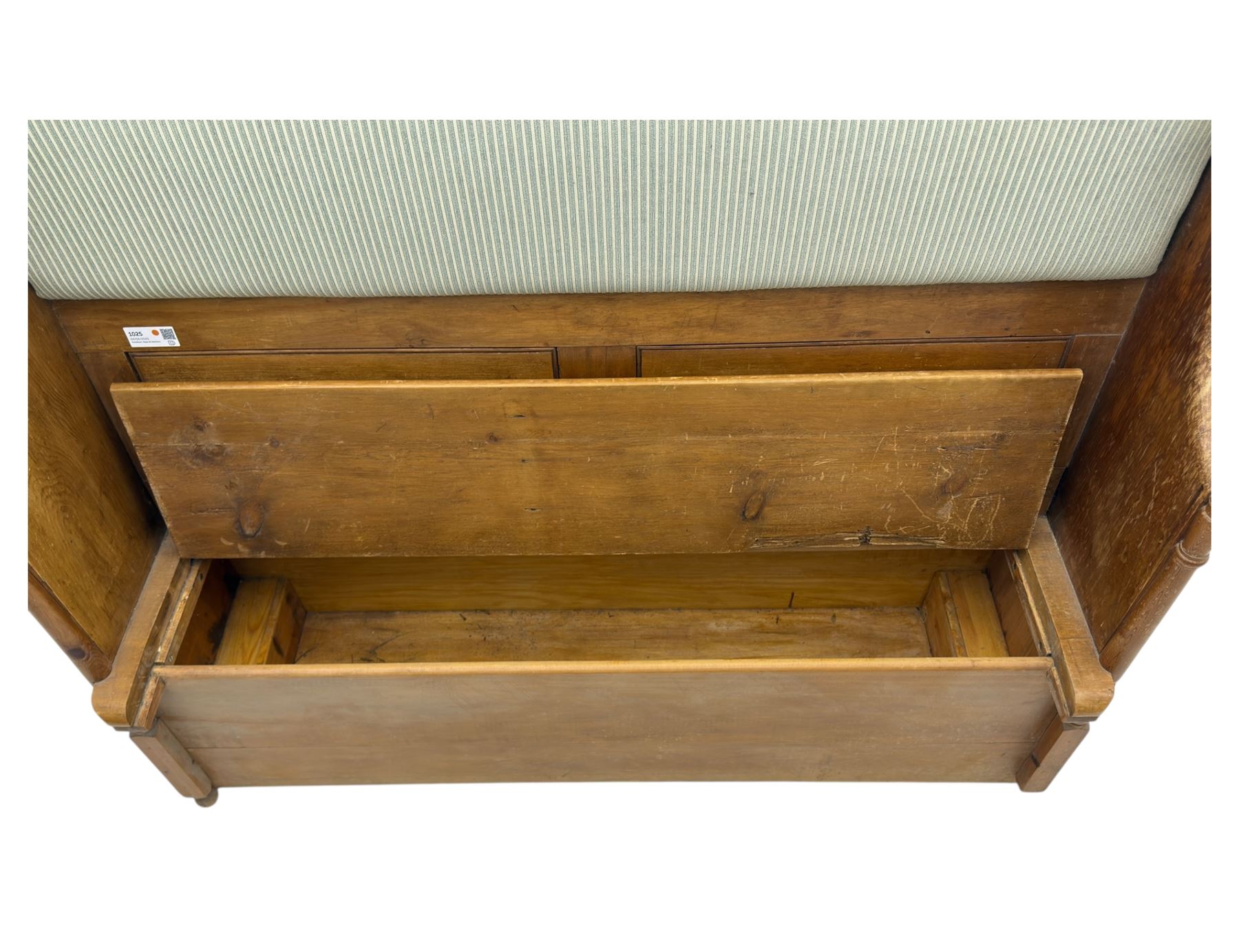 Early 20th century waxed pine pew, inset upholstered striped back panel with hinged box seat enclosing storage, shaped arms and turned supports