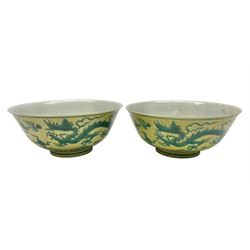 Pair of Chinese famille jaune bowls, decorated in green enamel with a dragon chasing a flaming pearl amongst clouds, upon a yellow ground, the interior decorated to centre with dragon, with six character mark beneath, D17.5cm