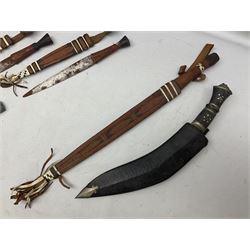 Indian kukri with 29cm curving steel blade and nickel mounted horn grip; in leather covered scabbard with one skinning knife L42cm overall; Hitler Youth knife with scabbard in relic condition; and three African graduated knives each with crudely carved wooden grips and painted leather covered scabbards (5)
