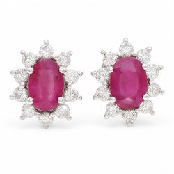 Pair of 18ct white gold ruby and diamond earrings, each stud set with a single oval cut ru...