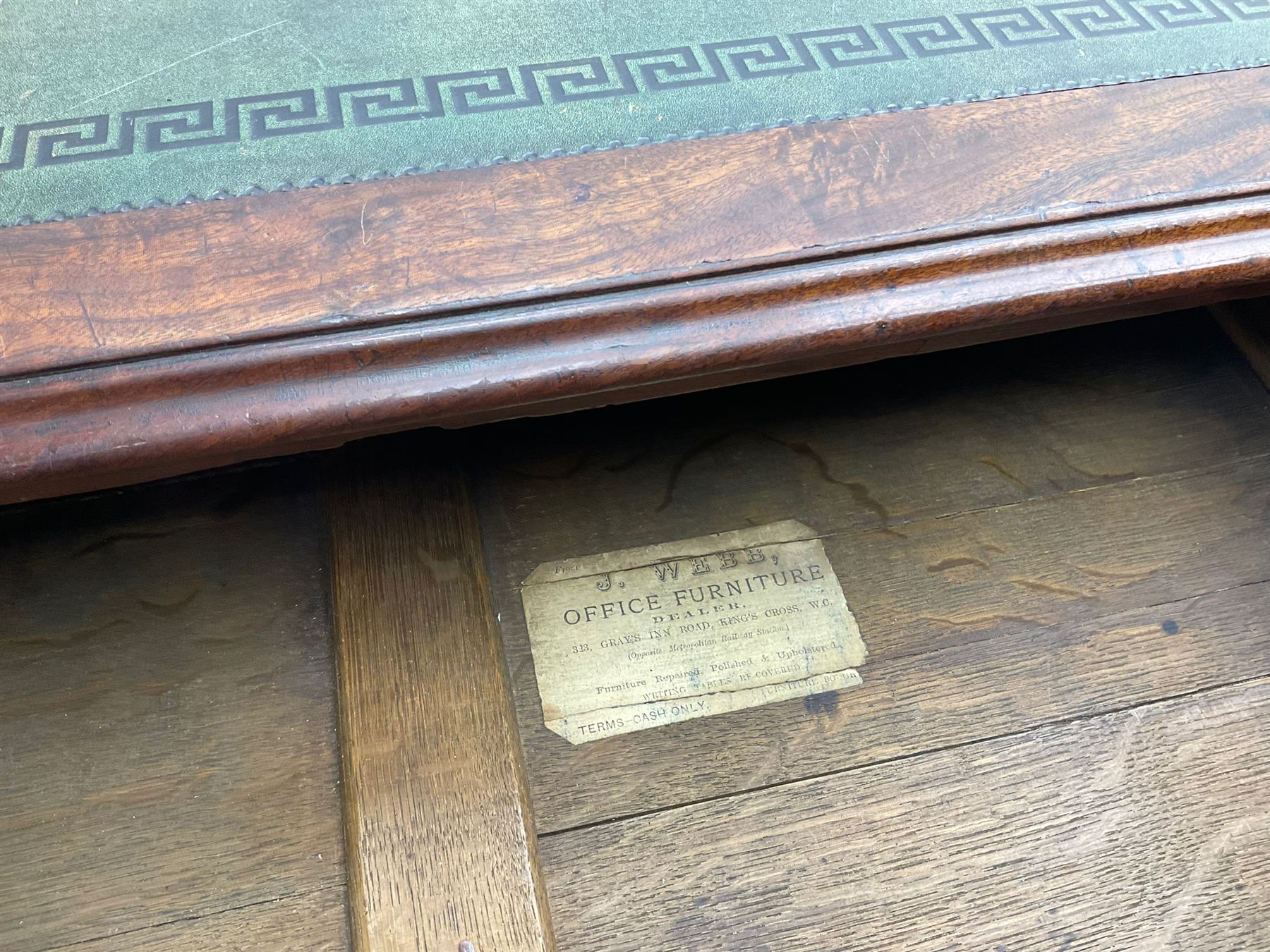 George III mahogany twin pedestal partners desk, rectangular top with moulded edge and an inset green tooled leather writing surface with Greek key design border, fitted with three cock-beaded frieze drawers to each side, each pedestal with three graduating drawers with an opposing panelled cupboard enclosing a single shelf, the facias fitted with brass lion mask plates with ring handles, the lower moulded edge over a plinth base and castors, London furniture dealers label to interior of drawer inscribed 'J. Webb, Office Furniture 323, Gray's Inn Road, King's Cross'  H75cm  W153cm  D97cm