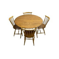 Ercol - circular drop leaf table on splayed tapering supports; together with four dining chairs