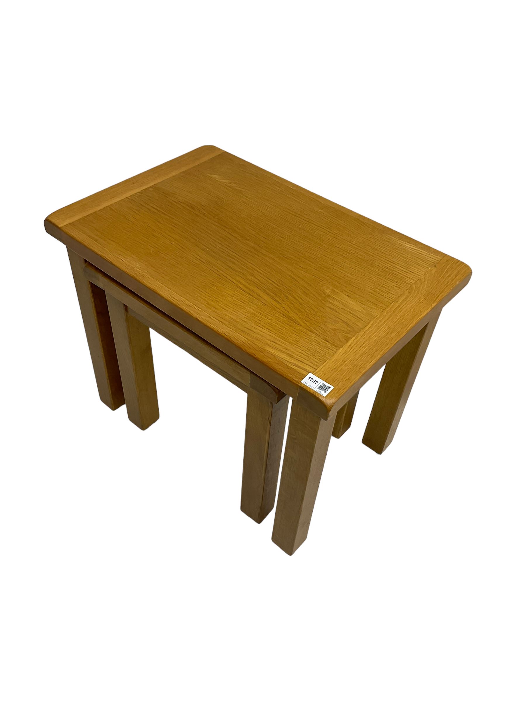 Light oak nest of two tables, rectangular top raised on square supports