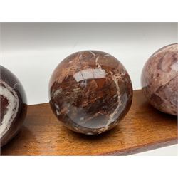 Set of three marble spheres on a elongated octagonal wooden base, H12cm