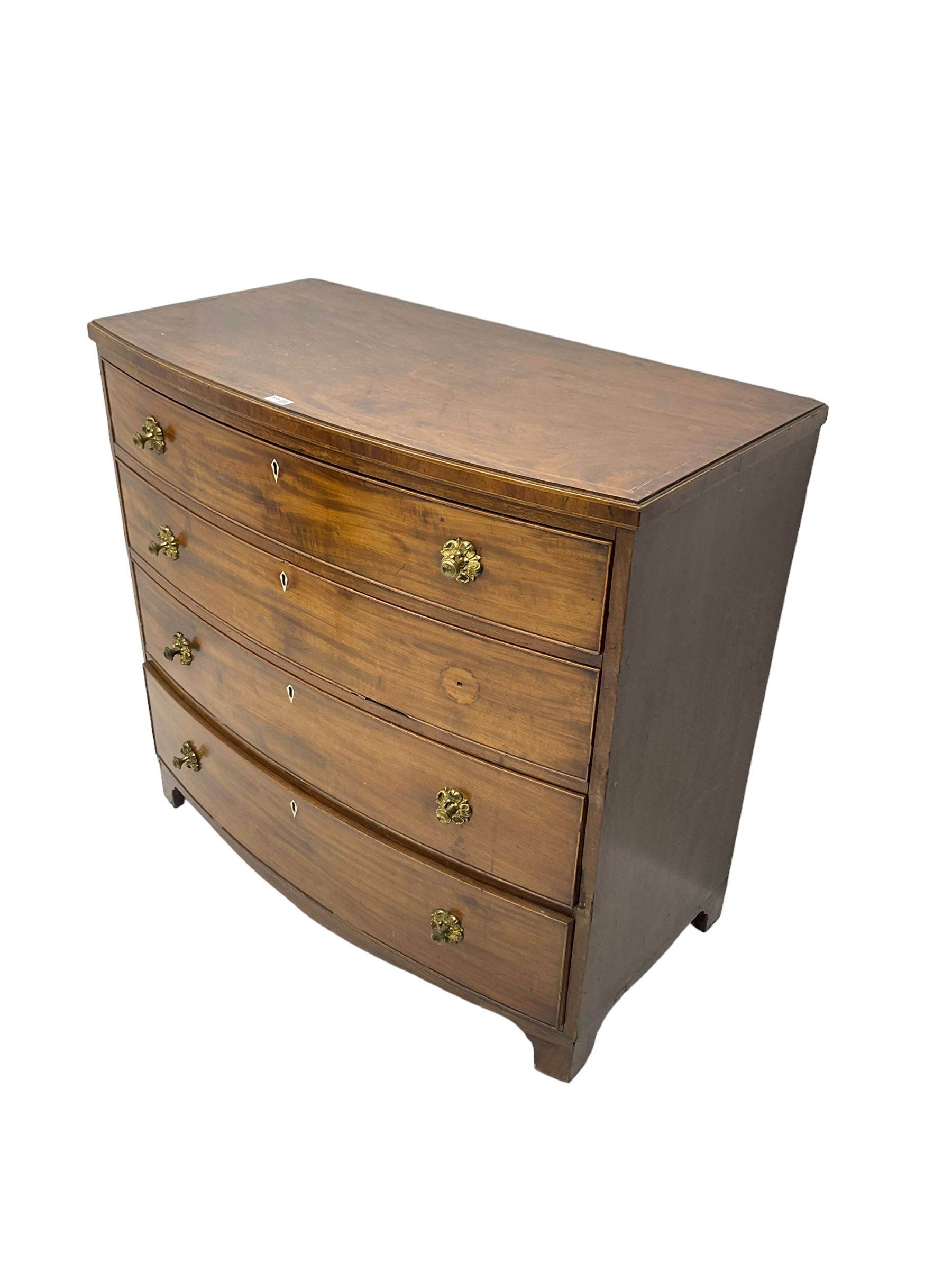 Regency mahogany bow front chest, the top with ebony and satinwood stringing, fitted with four cockbeaded drawers with brass pull handles and bone escutcheons, on bracket feet