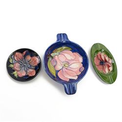Two Moorcroft ashtrays in Magnolia pattern and Anemone pattern, together with pin dish in anemone pattern  