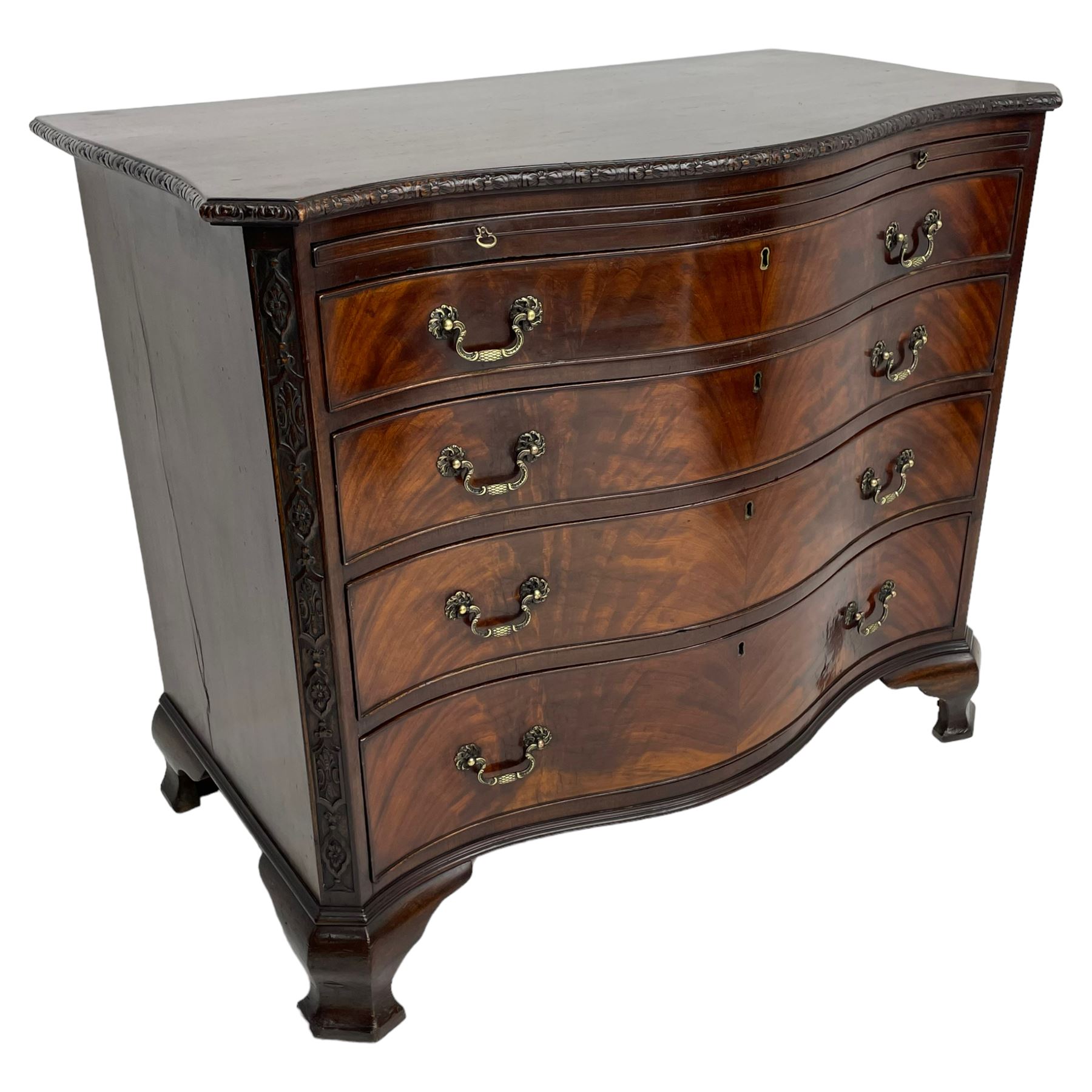 Chippendale design serpentine chest, shaped moulded top carved with repeating flower head motifs, fitted with brushing slide over four graduating drawers, pierced and foliate moulded handle plates with scrolled swan neck handles, canted upright corners carved with flower heads and strapwork, on canted ogee bracket feet