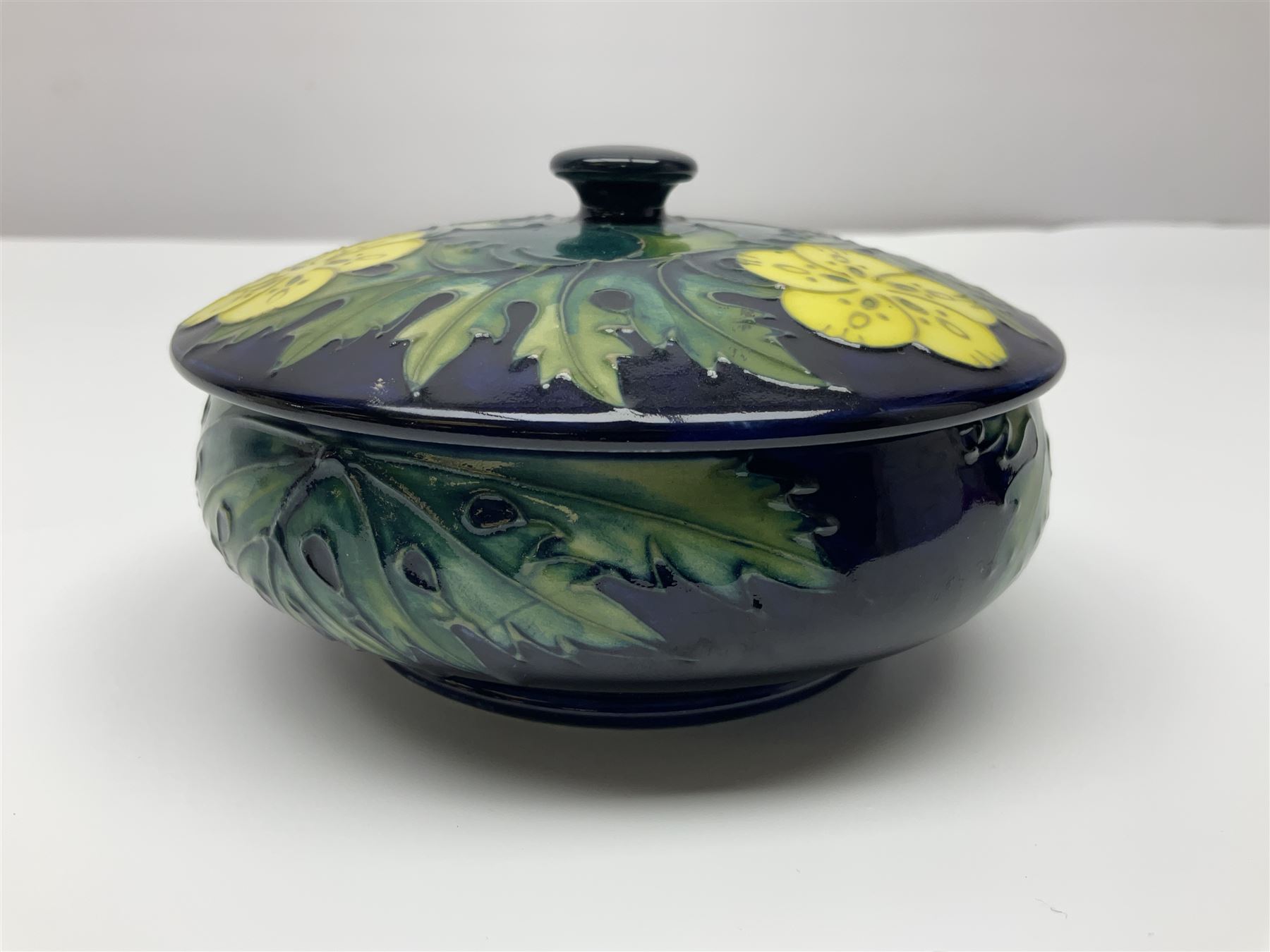 Moorcroft dish and cover, of circular form, decorated in Buttercup pattern, together with a Moorcroft vase, of baluster form, decorated in Magnolia pattern, both with printed marks beneath, tallest H9.5cm
