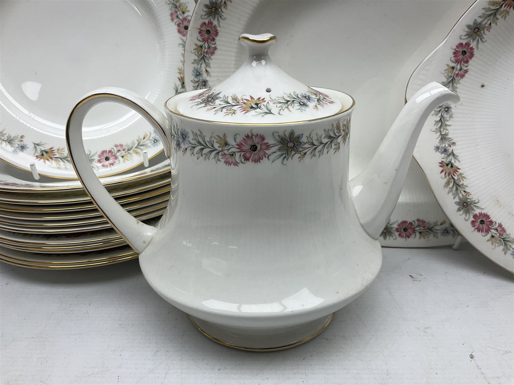 Royal Albert Paragon tea and dinner service for twelve decorated in the Belinda pattern, comprising fourteen saucers, twelve teacups, thirteen side plates, teapot, sauce boat and stand, salt and pepper shakers, two jugs, sucrier, twelve dinner plates, twelve smaller plates, two lidded tureens, twelve bowls, twelve smaller bowls, cake plate, oval plate and oval dish (100)