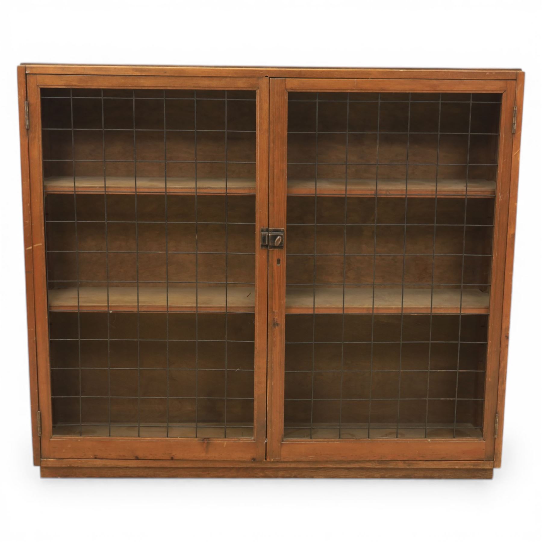 Rustic pine cupboard fitted with wire panelled doors, enclosing staggered adjustable shelving