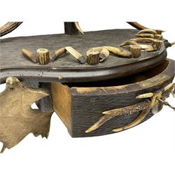 Black Forest design carved wooden gun or snooker cue stand, decorated with Red Deer and Fellow Deer antlers, to hold seven cues 