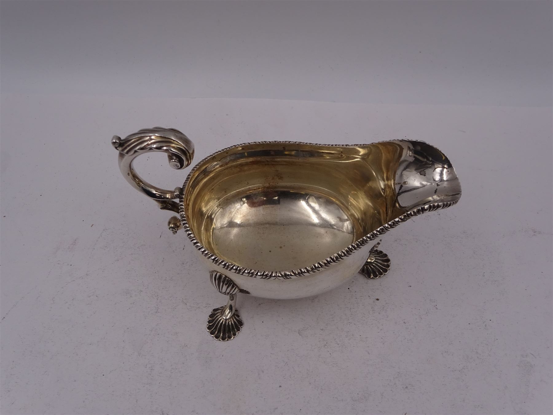 Victorian silver sauce boat, of typical form with oblique gadrooned rim and acanthus capped flying C scroll handle, upon three shell pad feet, hallmarked Charles Stuart Harris, London 1898, including handle H10cm