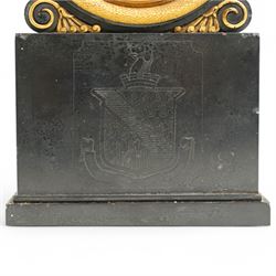 Benjamin Vulliamy of London- a small Regency 8-day ormolu and black marble mantle timepiece c1820, circular movement with a drum housing cradled on decorated scroll supports and a stepped marble plinth, the front of the plinth faintly incised with an armorial coat of arms, 3-1/2
