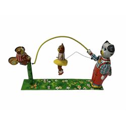 Gebruder Bing Germany Pigmyphone child's portable toy gramophone in woodgrain finish tin-plate box with key and tin of needles L15cm; and nine small records of nursery rhymes; together with a Japanese tin-pate 'Skip Rope Animals' clockwork toy, boxed.
