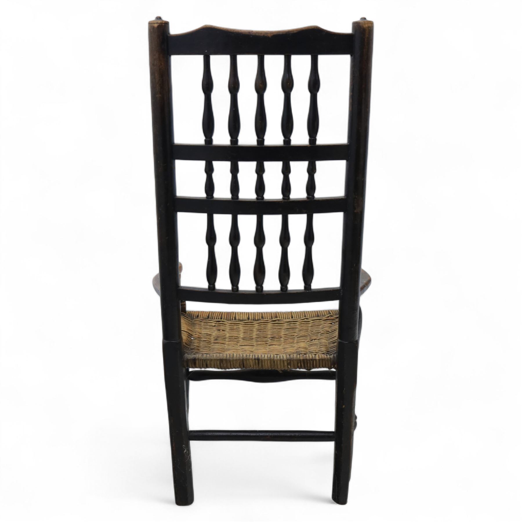 19th century country elm spindle back armchair, shaped cresting rail over two rows of turned spindles, shaped open arms over rush seat, on front turned supports, joined by stretchers 