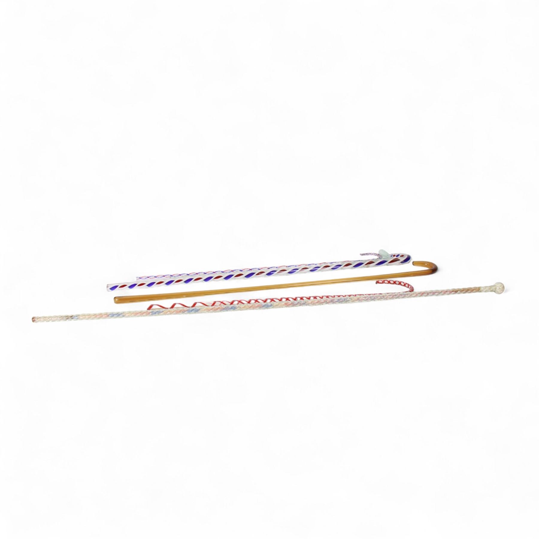 Six Victorian glass walking canes, to include three 'frigger' examples with colour twist designs, a 'hundreds and thousands' example with knop finial and filled with micro beads, possibly Nailsea, an opaque green twist example, and an amber glass example, longest L130cm