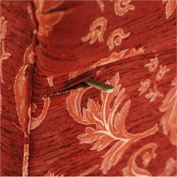 Edwardian hardwood framed petite two seat settee with single drop-arm, traditional shape with rolled arms, the drop-end with lever action adjustable height, the sprung back and seat upholstered in crimson foliate patterned fabric, on compressed bun feet