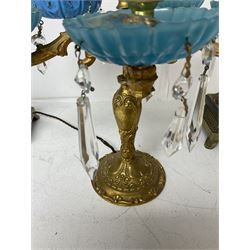 Brass table lamp, modelled as a candelabra with five branches, each with blue glass candle holders with crystal drops, H47cm, together with a pair of cast metal table lamps with acanthus leaf detail, upon a stepped square base, with red fabric feather and tassel shades, H78cm