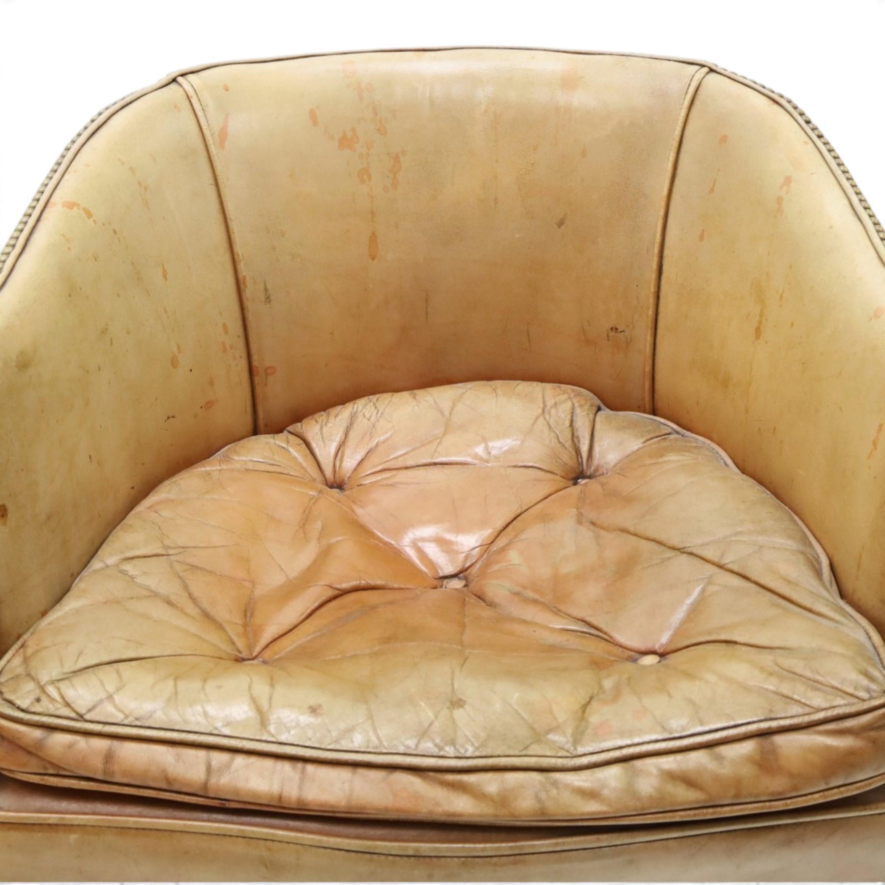 Early 20th century Georgian design mahogany framed desk or club armchair of tub form, with turned pilaster arm supports and legs with rear splayed supports, upholstered in faded tanned leather with loose seat cushion