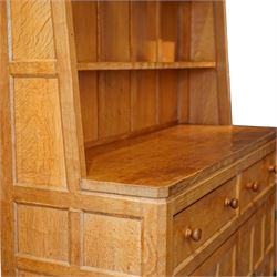 Rabbitman - adzed oak Welsh dresser, scalloped cornice above two plate racks, adzed and panelled sides, the lower integrated section with adzed oak top, over two drawers above twin cupboard doors with blackened metal latch and hinges, carved rabbit to the right hand side, by Peter Heap of Wetwang