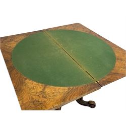 Victorian figured walnut card table, the moulded fold-over top with circular baize playing surface, faceted vase shaped baluster column, on quadruple splayed and s-scroll supports, brass castors