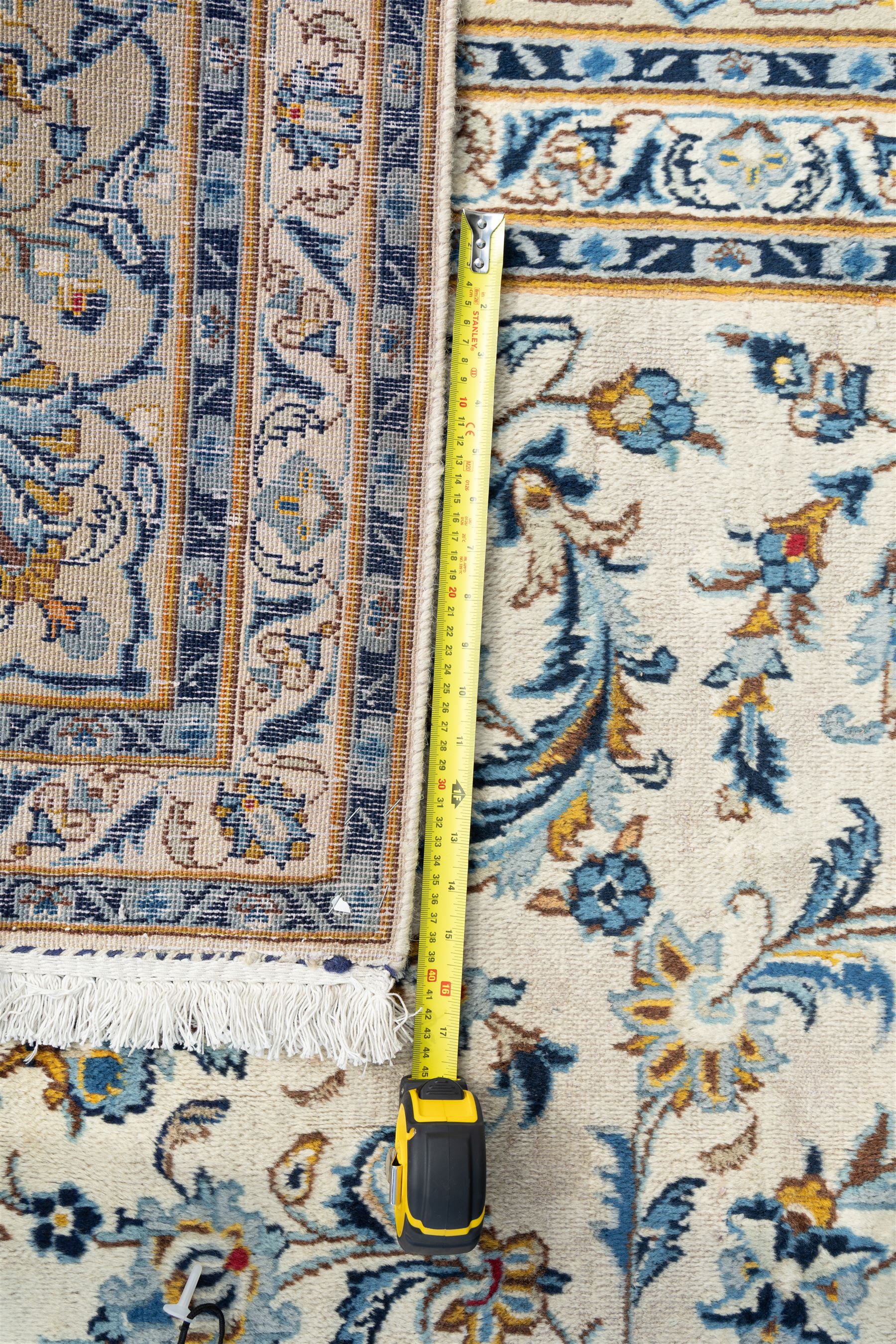 Central Persian Kashan hand-knotted carpet, ivory field profusely decorated with an all-over scrolling vine, palmette, and lotus design in shades of soft blue, pale gold, and green within floral borders