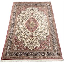 Finely knotted Persian Qom silk rug, overall pink ground with ivory field, the field with central cusped medallion profusely decorated with interlacing foliate and stylised flower heads, multiple band boarder, the main band decorated with a series of stylised motifs and trailing foliage, the outer guard with signature panel 