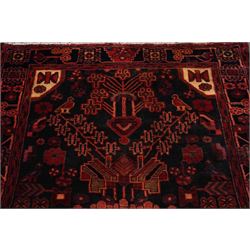 Persian Hamadan runner rug, the indigo ground decorated with stylised flowering plants and geometric motifs in crimson, rose and ivory, enclosed by an indigo flowerhead border and narrow red guard stripes