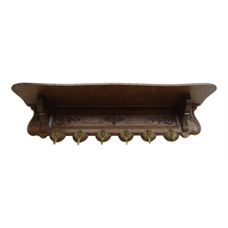 20th century French oak wall hanging coat rack, relief carved with scrolls and acanthus leaves, six gilt hooks cast with masks, W120cm  