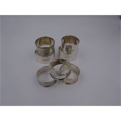 Seven silver napkin rings, of varying design, including examples with engine turned and engraved decoration, all hallmarked with various dates and makers 