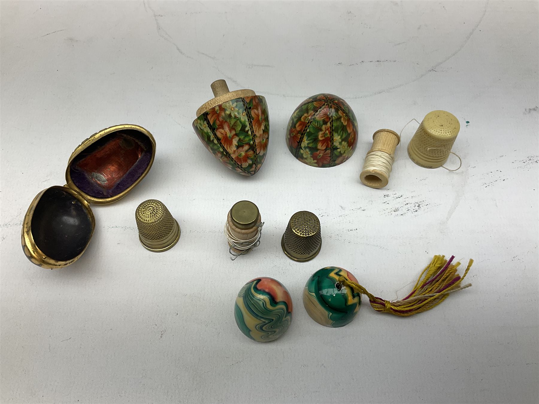 Collection of early 20th century and later thimble holders, to include a coquilla nut example, a floral decorated examples etc together with parquetry wooden tape measure 