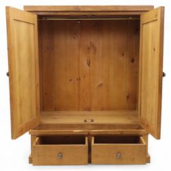 Contemporary pine hanging wardrobe, twin panelled doors enclosing open hanging space with brass rail, two drawers to lower section, on moulded plinth base