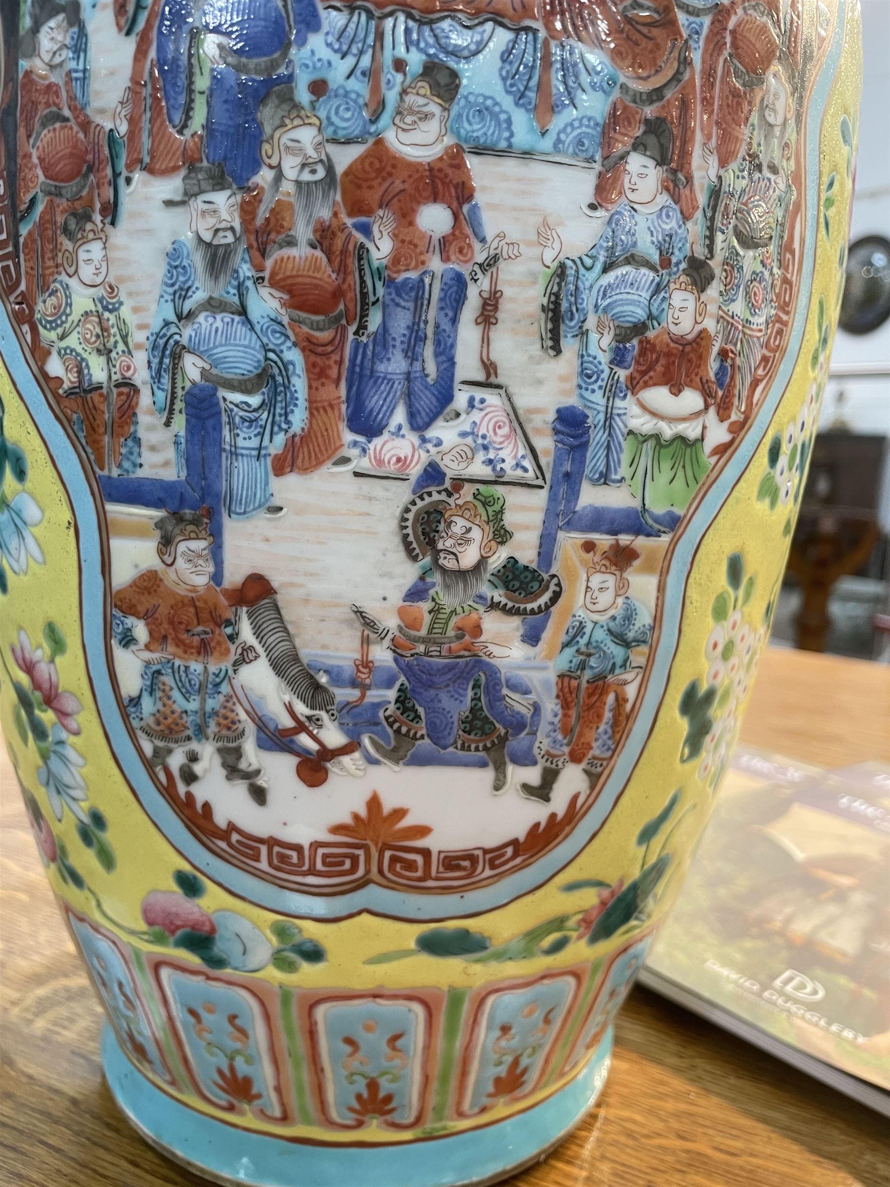 19th century Chinese famille rose yellow ground porcelain vase, of baluster form with twin applied mask ring handles, the body decorated with two shaped reserves mounted with dragon heads, depicting warriors at battle and at court, the neck with two smaller conforming figural reserves, upon a yellow ground decorated with exotic birds amidst scrolling blossom, H45.cm