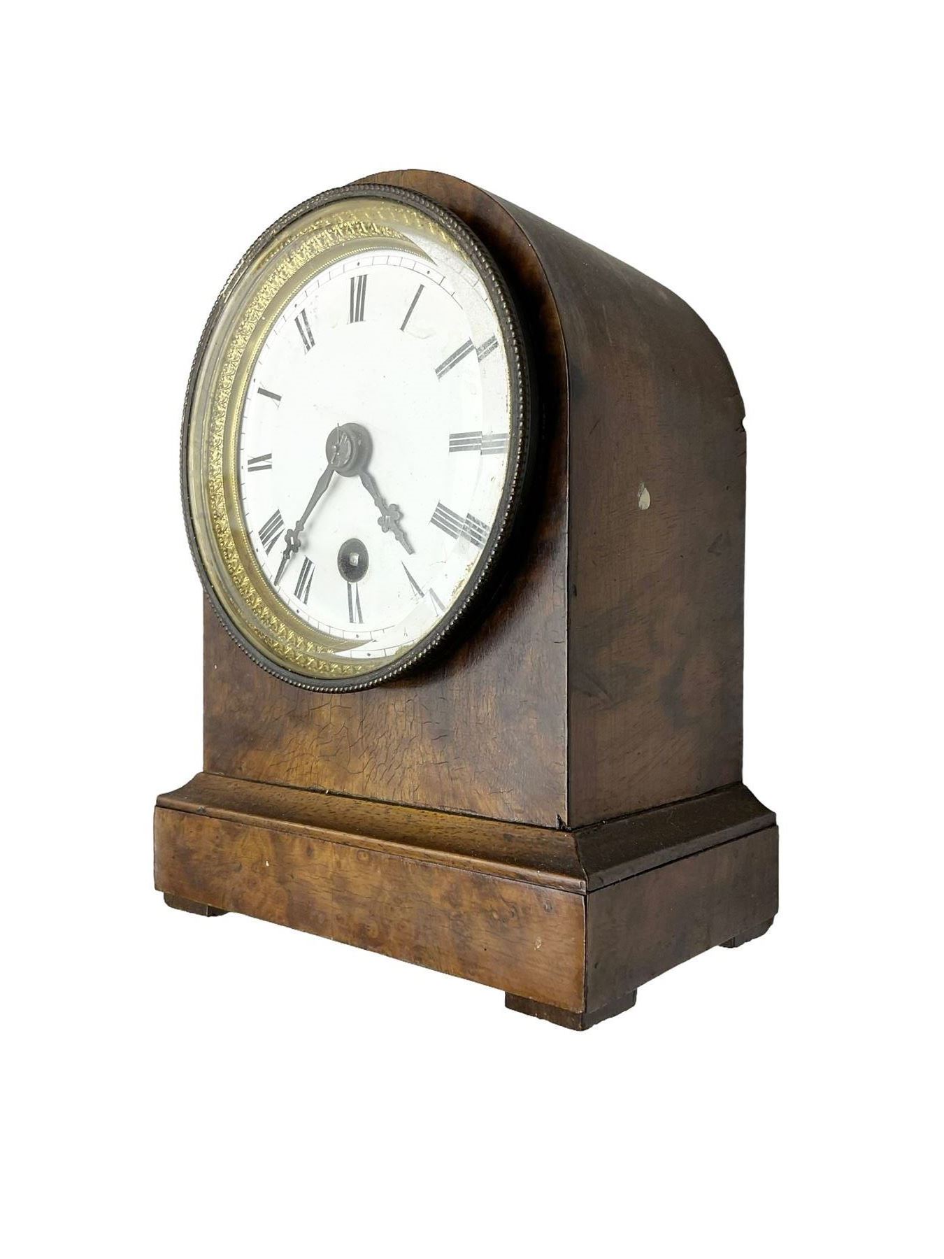French - late 19th century 8-day walnut table clock, with a round top and shallow plinth raised on block feet, enamel dial with Roman numerals and minute track and decorative pierced steel hands within a gilt slip and cast brass bezel, single train movement with a spring driven going barrel. With pendulum. 