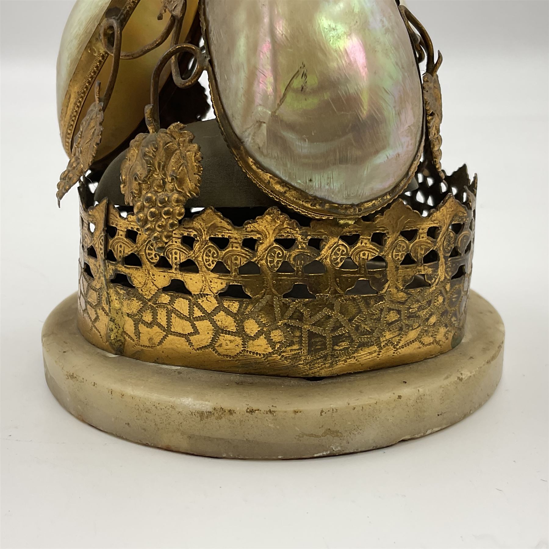 Victorian evening dinner bell, with three mother of pearl shells, floral and grape gilt decoration, and bird finial, raised upon a circular soapstone base with gilt pierced gallery, H14cm