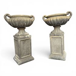 Pair of Neoclassical design weathered cast stone garden urns of kylix form, the rolled rim...
