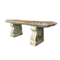 Weathered cast stone three piece bench, the rectangular seat with moulded edge, raised on ...