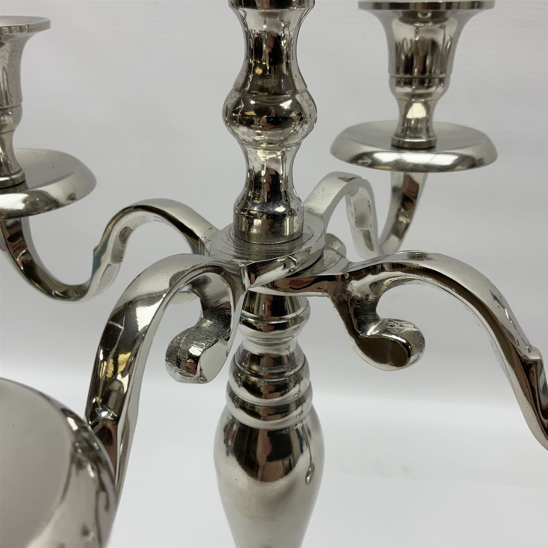 Pair of four branch candelabras, urn-shaped nozzles raised upon scroll branches supported from tapering central stem, with a stepped circular base, H40cm