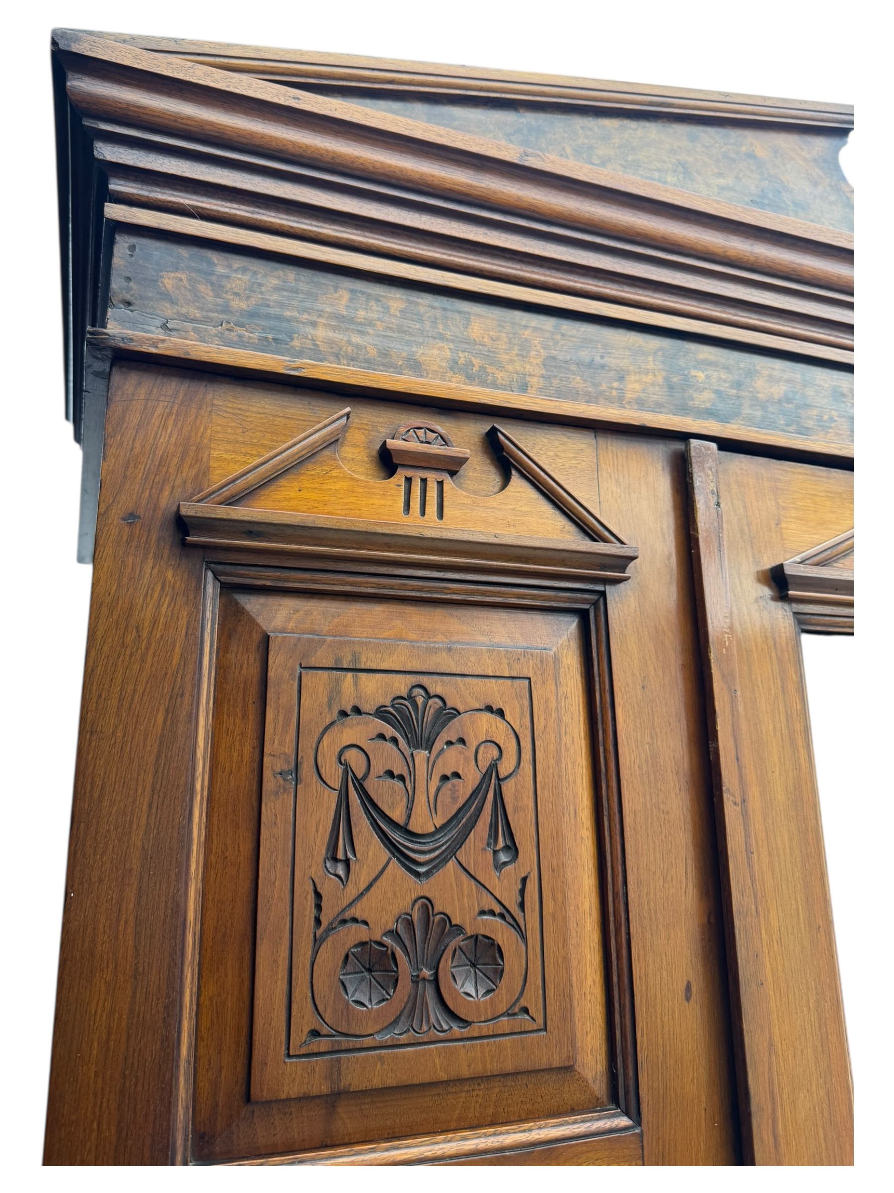 Victorian walnut bedroom suite - wardrobe, dressing chest and bedside cupboard, comprising a full-length wardrobe with broken pediment and central mirrored door, large lower drawer, a matching dressing table with bevelled swing mirror over two trinket drawers and two short drawers over two long drawers, and a single-door bedside cupboard, all with moulded edges, decorative panel work and shaped aprons