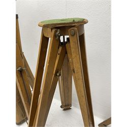 Three wooden adjustable tripods for plate cameras, together with a Linhof of Munchen metal tripod in a canvas case 