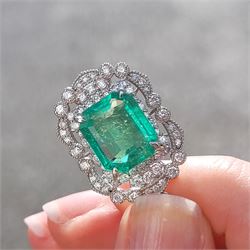 Platinum Colombian emerald and diamond pendant necklace, single octagonal cut emerald of 7.38 carat, surrounded by round cut diamonds in a fancy milgrain pierced design setting, stamped Pt 950, on a trace link chain necklace, total diamond weight 1.14 carat, with GCS certificate